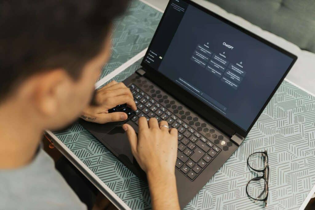 What to Learn in Tech in 2025: Beginner’s Guide to Top Careers 4 A man working on a laptop with AI software open on the screen, wearing eyeglasses.