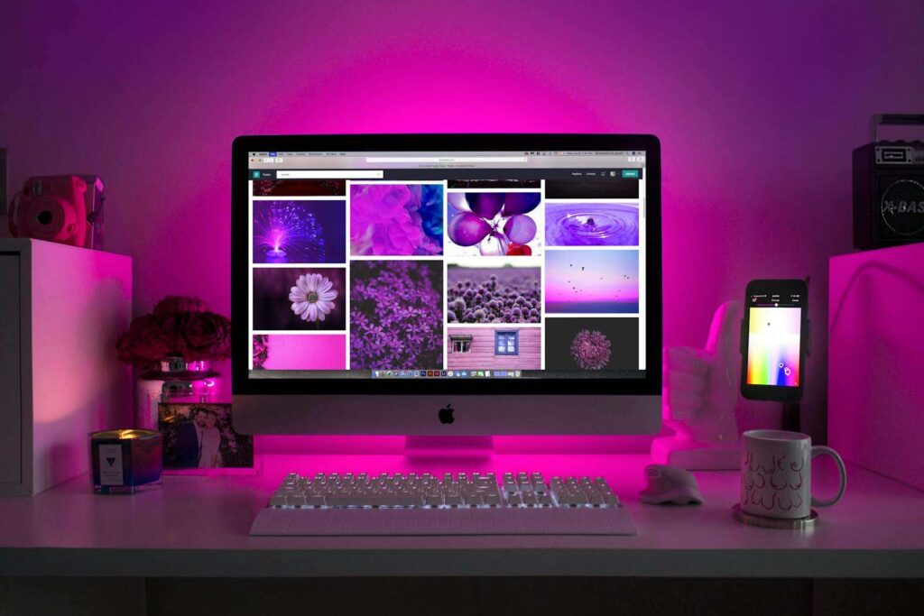 What to Learn in Tech in 2025: Beginner’s Guide to Top Careers 7 Modern desk setup with neon lighting and a desktop computer displaying colorful images.
